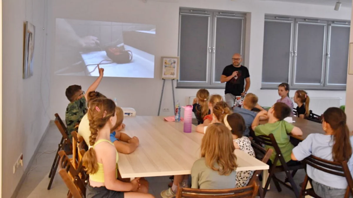 Dzieci rozwiązujące łamigłówki przy stolikach w Miejskiej Bibliotece Publicznej w Limanowej