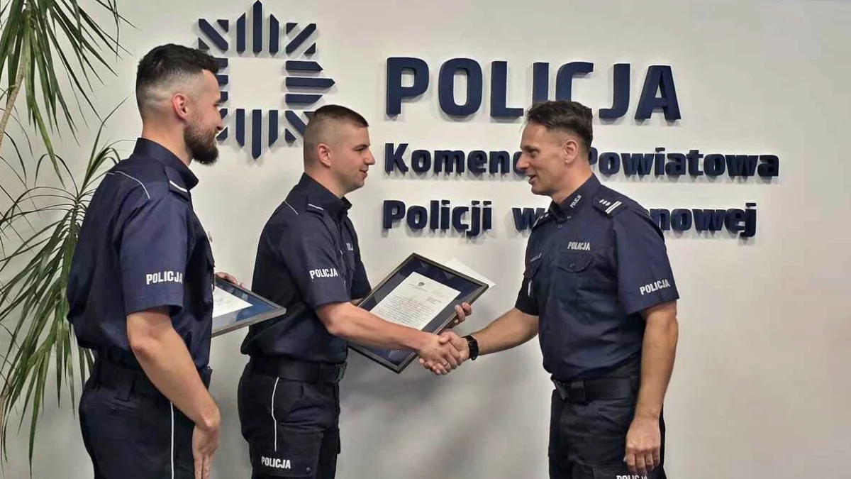 Limanowscy policjanci odbierający gratulacje i torby medyczne od kadry kierowniczej w sali narad