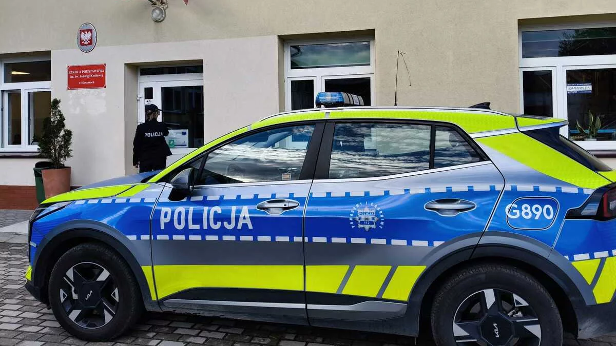 Policyjny radiowóz przed budynkiem szkoły w Małopolsce