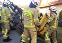 Koparka spadła z pojazdu i uszkodziła ogrodzenie - zdjęcie główne