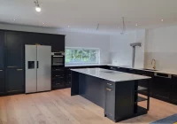 Biało-czarna kuchnia z wyspą w Nowym Sączu - tu nowoczesność łączy się z klasycznymi rozwiązaniami - zdjęcie główne