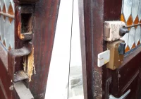 Uszkodzone drzwi do kaplicy na cmentarzu - zdjęcie główne