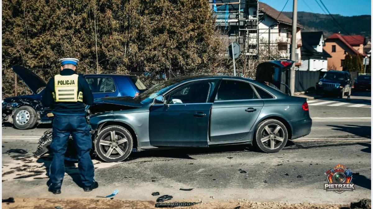 Samochody pośrodku jezdni po kolizji drogowej na ulicy Kolbego w Mszanie Dolnej i policjant wyjaśniający okoliczności zdarzenia
