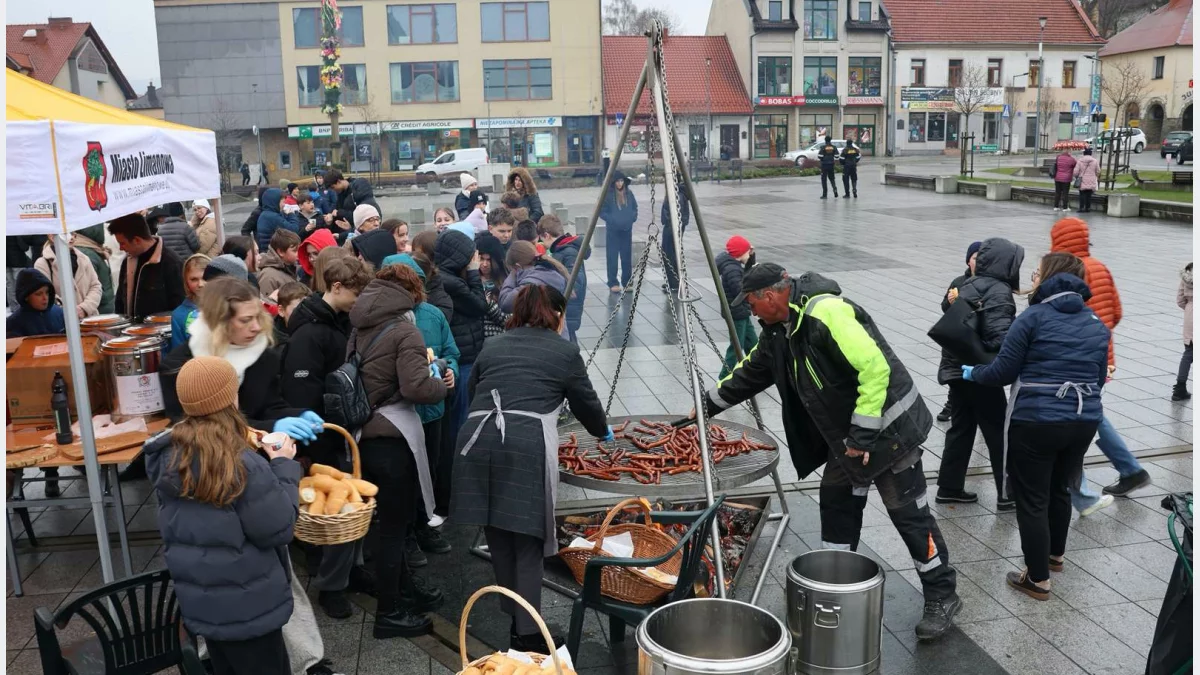 Uczniowie w odblaskowych kamizelkach zbierający odpady do worków w Parku Miejskim w Limanowej.