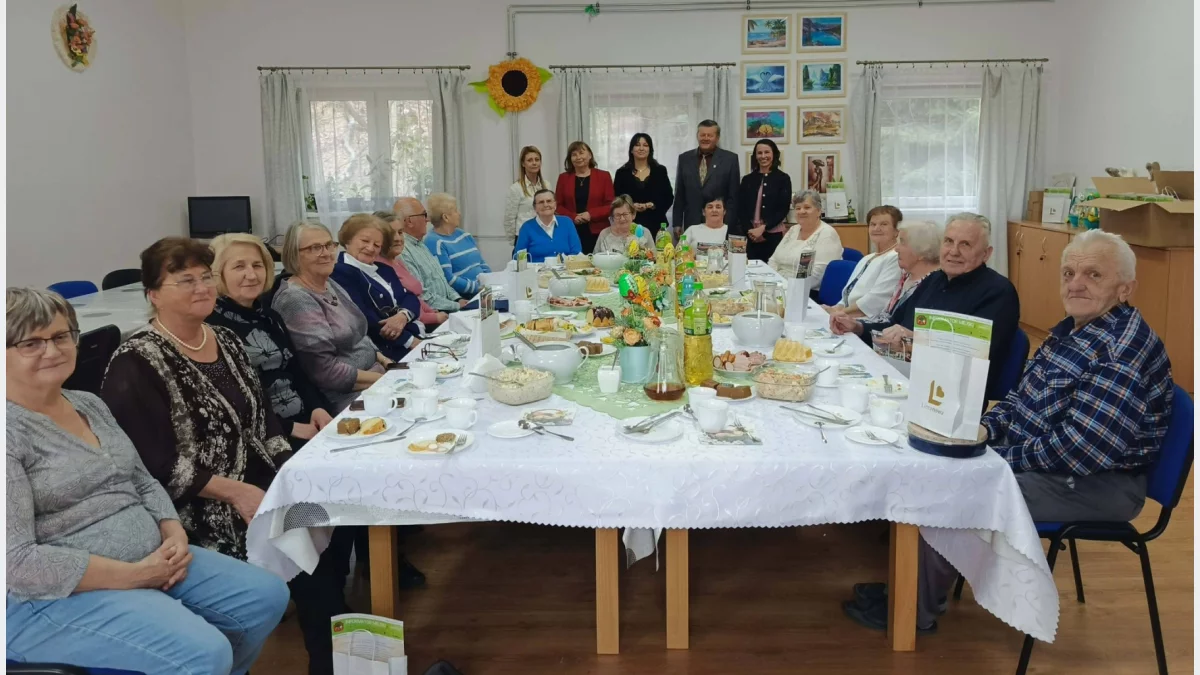 Seniorzy i przedstawiciele władz miasta przy wielkanocnym stole w Dziennym Domu Senior+ w Limanowej.