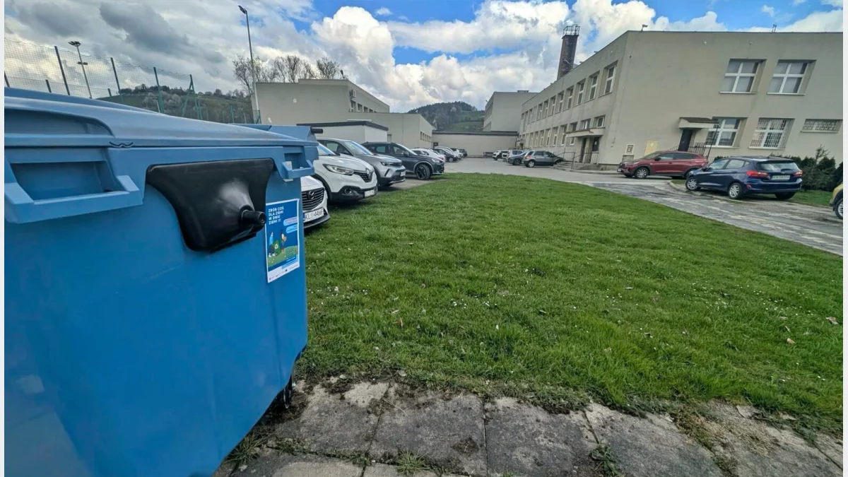 Kontener na papier i tekturę stojący przed budynkiem szkoły podstawowej w Limanowej.