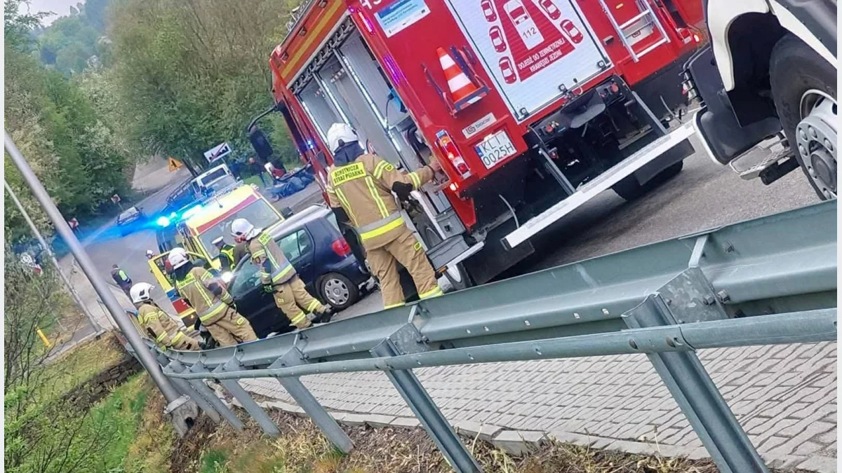 Samochody strażackie i karetka pogotowia na sygnałach na miejscu kolizji na drodze w Zalesiu