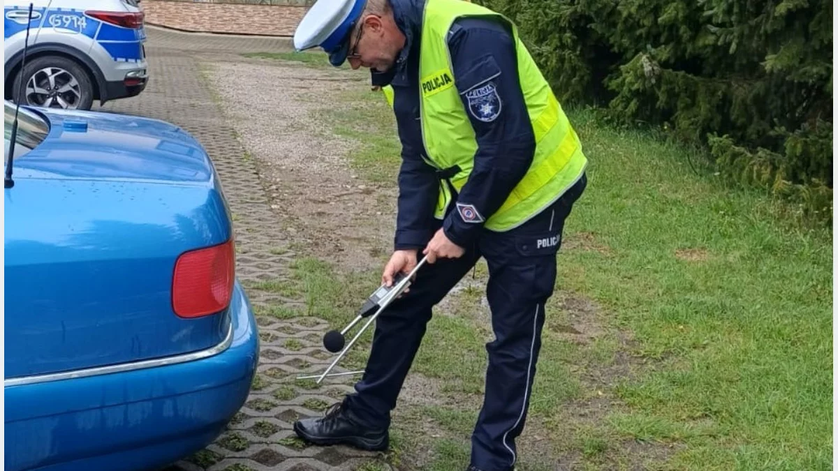 Policjant ruchu drogowego z zatrzymanym do kontroli samochodem