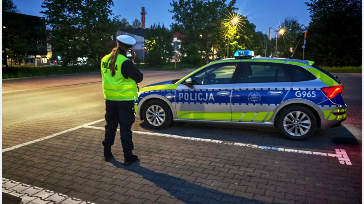 Radiowóz policyjny i funkcjonariusza Wydziału Ruchu Drogowego podczas kontroli prędkości na ulicy w Limanowej