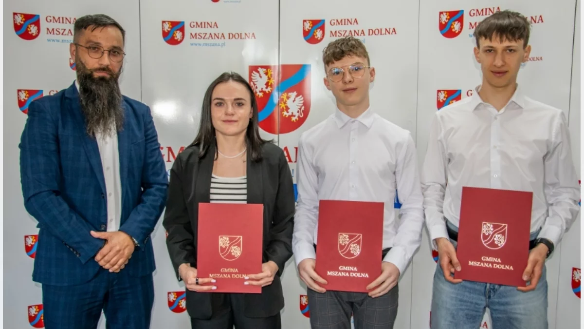 Trójka młodych sportowców odbiera dyplomy i gratulacje od władz gminy Mszana Dolna podczas sesji rady.