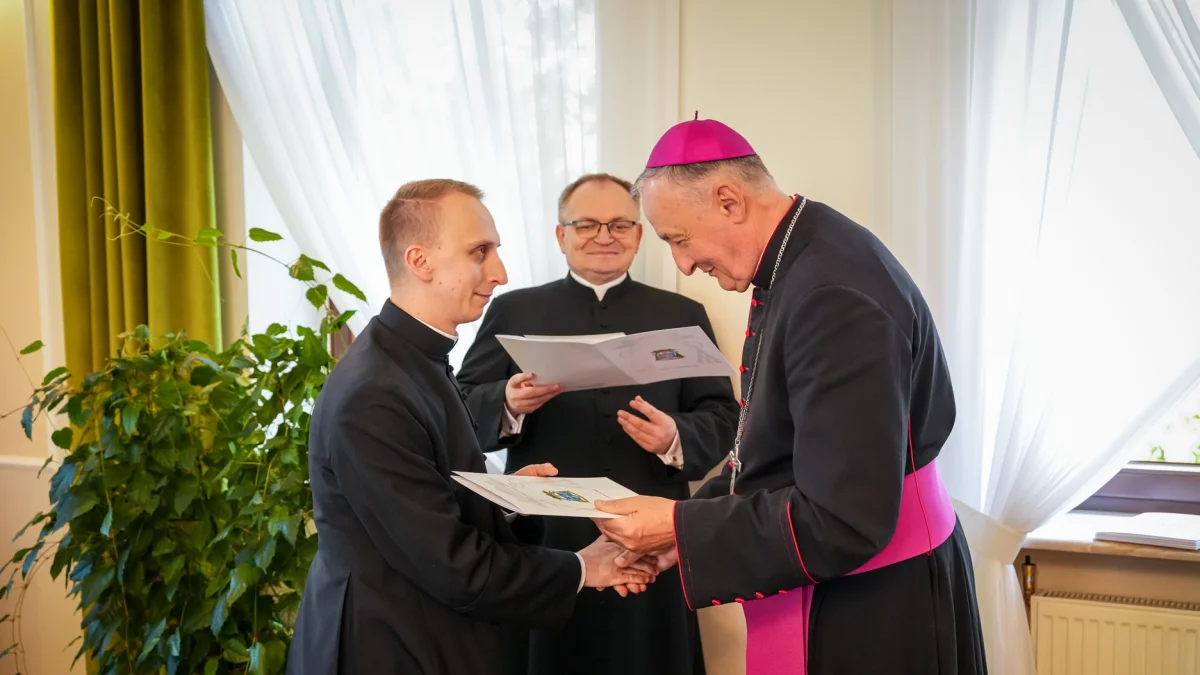 Biskup tarnowski Andrzej Jeż wręcza dokumenty nominacyjne nowo wyświęconym kapłanom w Domu Biskupim w Tarnowie
