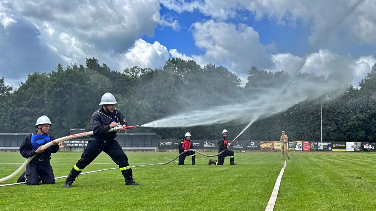 Strażacy ochotnicy rywalizujący w konkurencjach sprawnościowych na stadionie sportowym